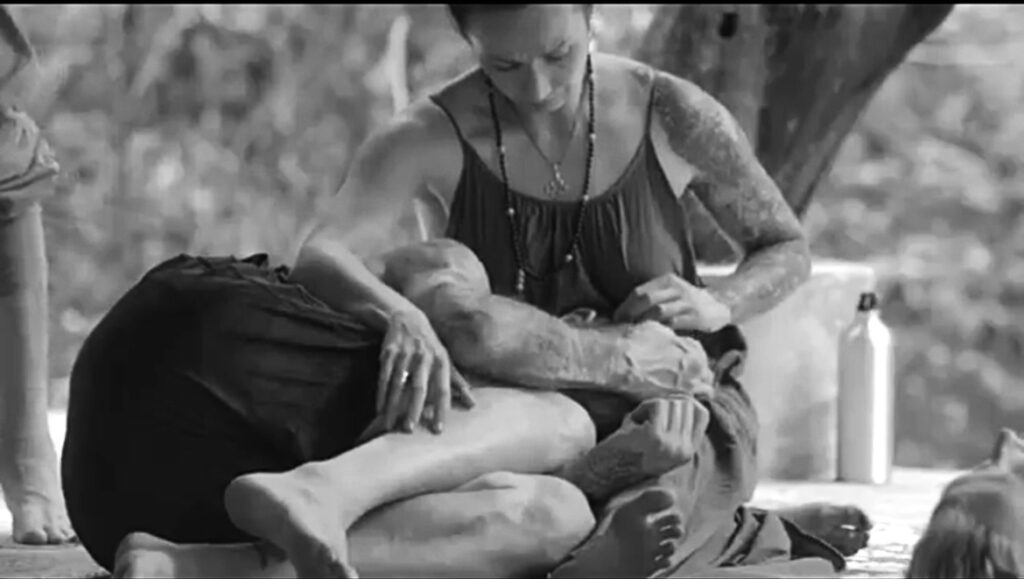 Breathwork facilitator providing hands-on support during a conscious connected breathwork session